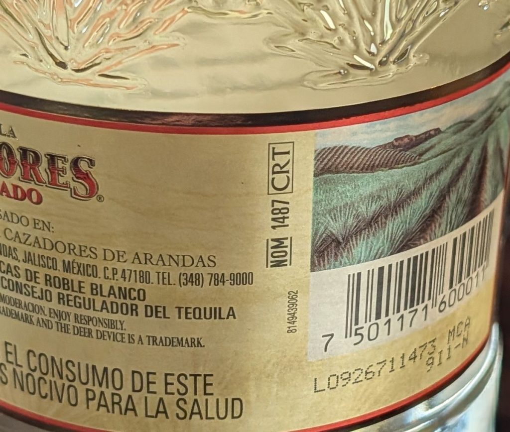 Back label of a Tequila Cazadores Reposado bottle showing NOM 1487 and the CRT seal
